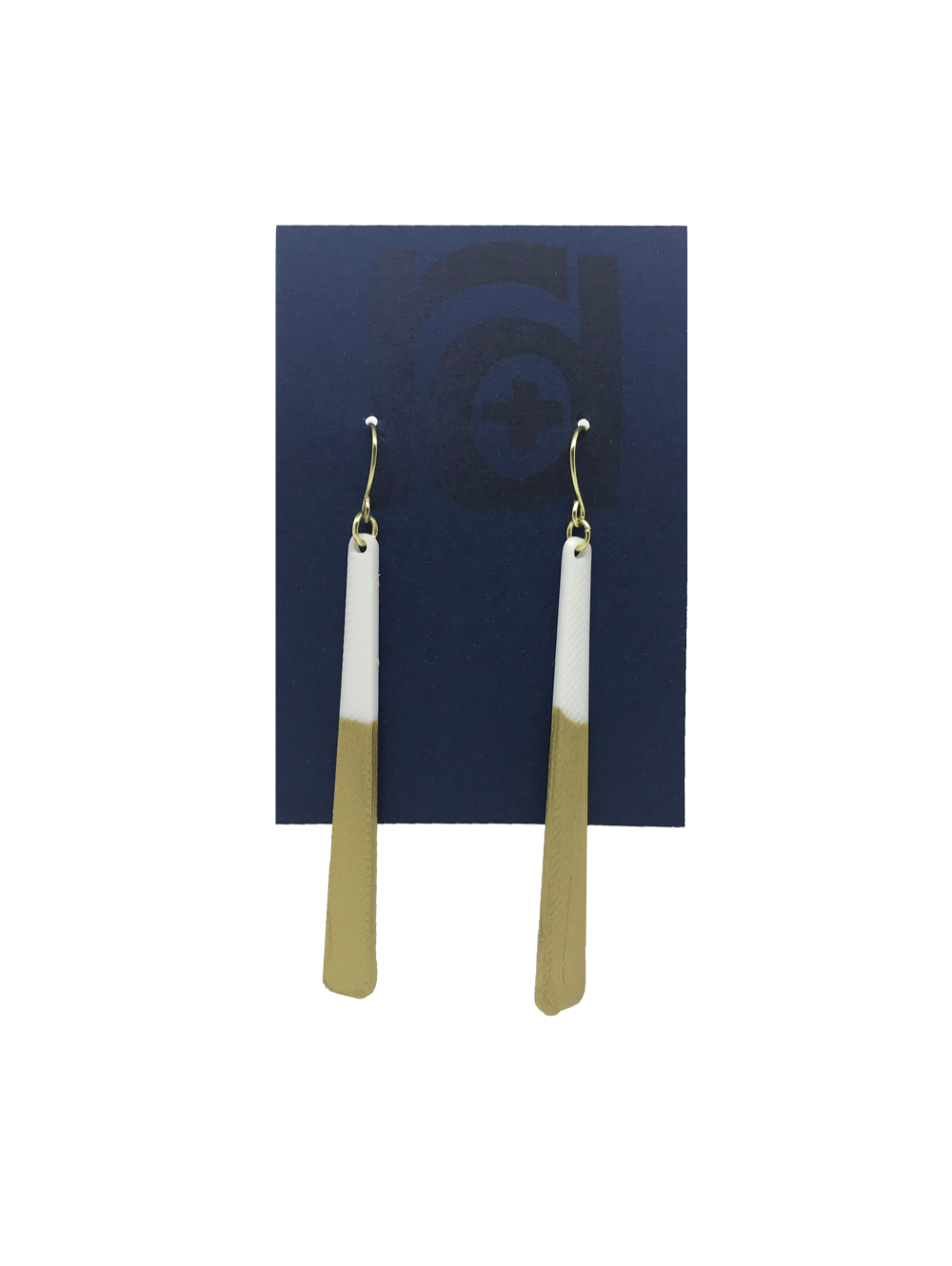 Shown on a sustainable dark blue earring card, these earrings are long dangles that flare out slightly. The white plant based earring is dipped into metallic gold paint to give a perfect shimmering accent. 