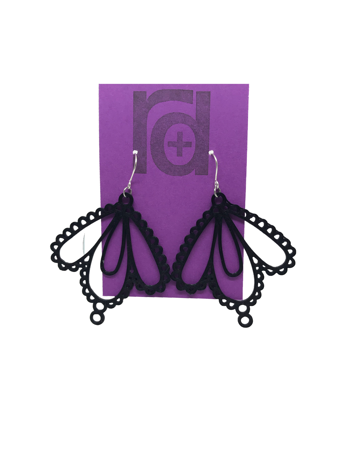 Two earrings on a purple earring card: they have three teardrop shapes and are reminiscent to lace. These 3D printed earrings are made with a black sustainable filament.