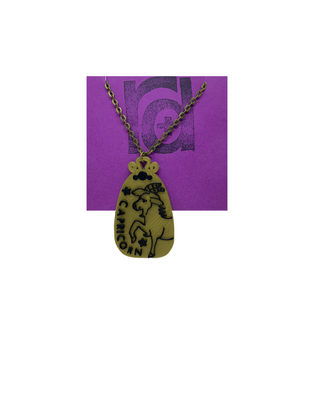 Hanging from our recyclable R+D necklace card is a gold zodiac pendant with black details. It is 3D printed with a plant based filament. This pendant has the sign Capricorn on it with a goat and stars