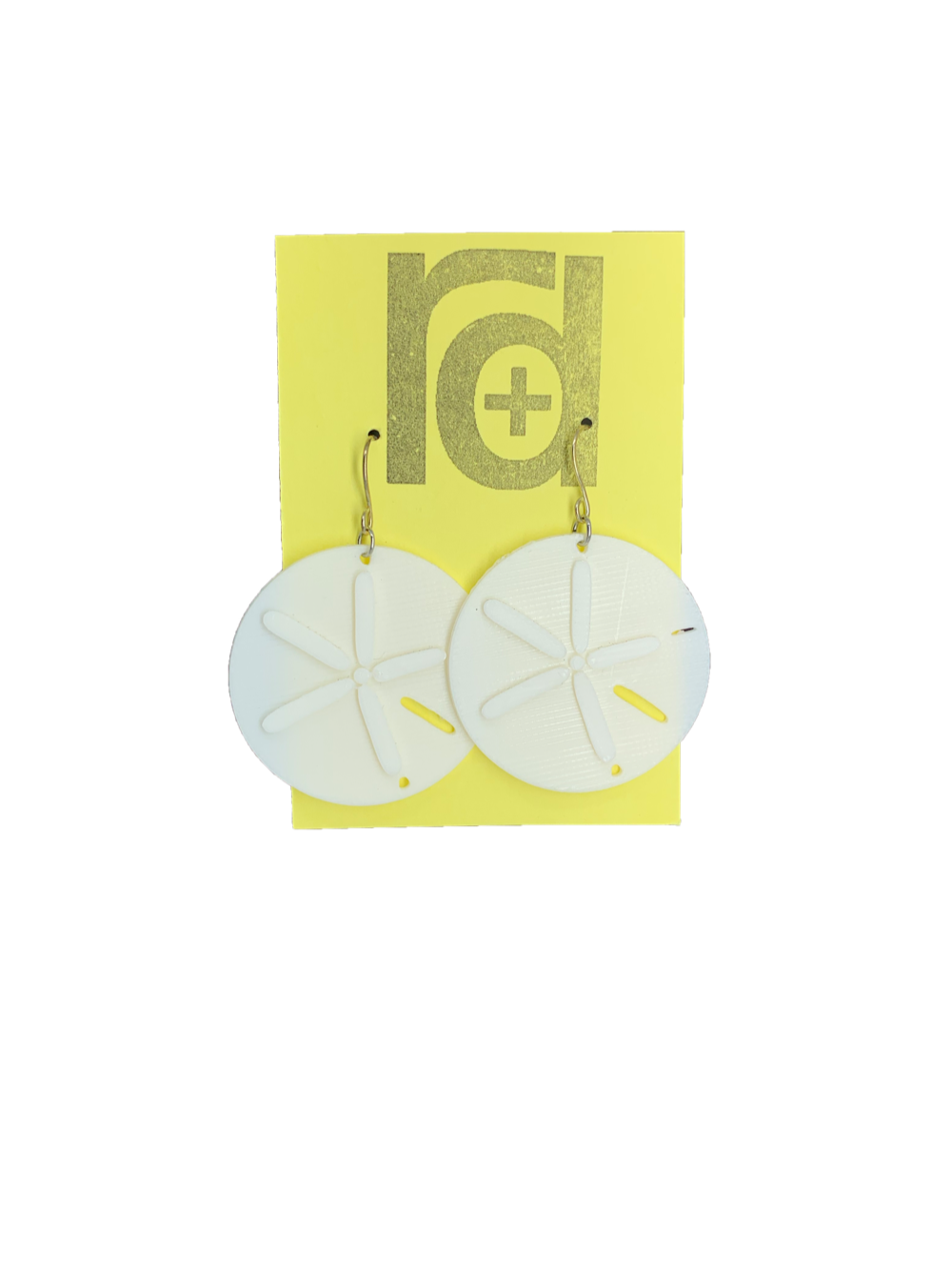 Two white earrings on a yellow earring card. The earrings look like sand dollars with a star burst patten that is raised from he surface. 