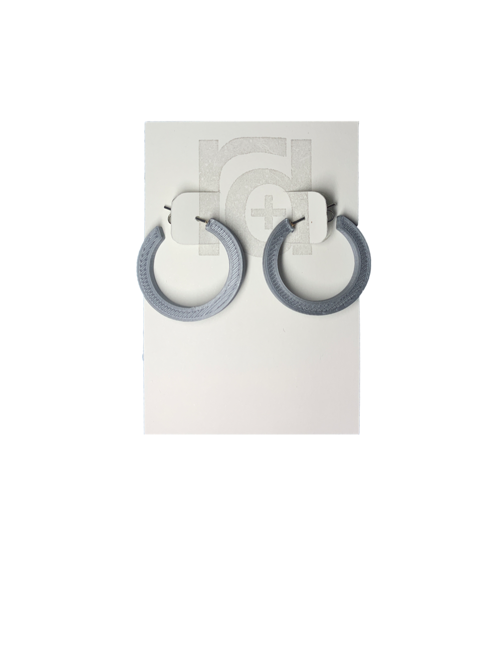 On a white R+D earring card are two chunky hoops. They are printed in an eco friendly silver color.