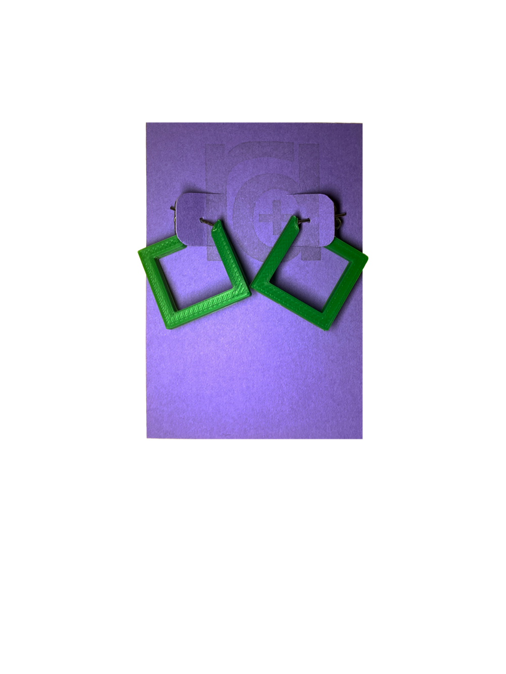 On a bight purple R+D card are two 3D printed earrings. They are hoops that are in the shape of squares. These are printed in a bright kelly green. 