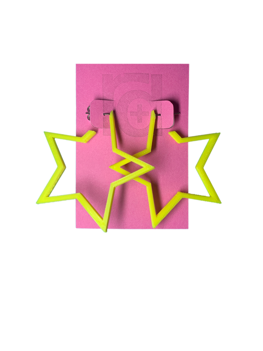 On a bright pink card are two R+D earrings. The earrings are yellow star hoops that are 3D printed with a plant based filament. 