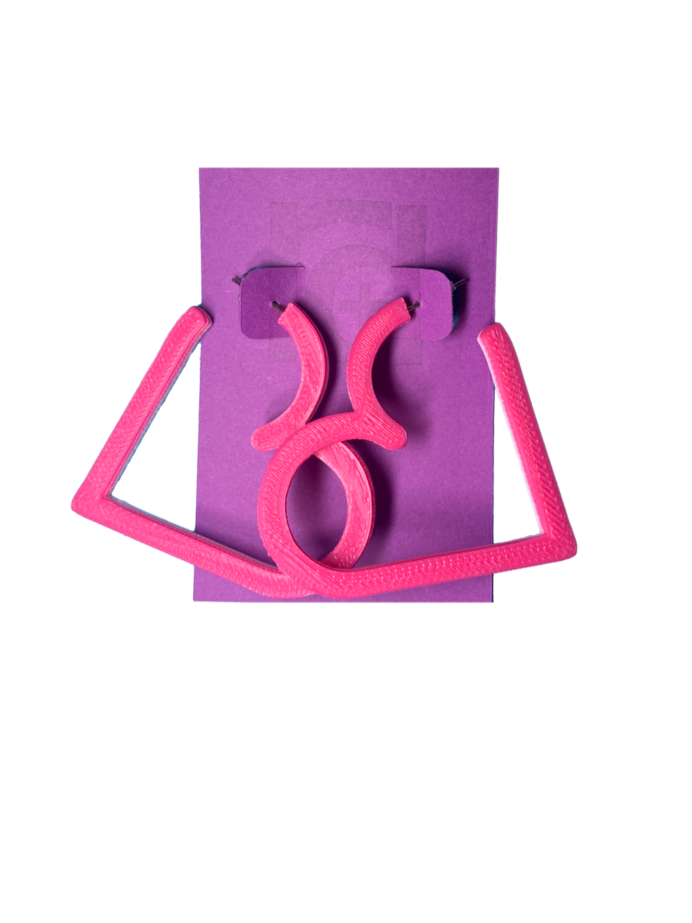 On a purple R+D card is a pair of 3D printed hoops. They are in the shape of a heart with bright hot pink visible on the top layer. Printed with a plant based filament, there are three colors layered: hot pink, light pink, and white. 