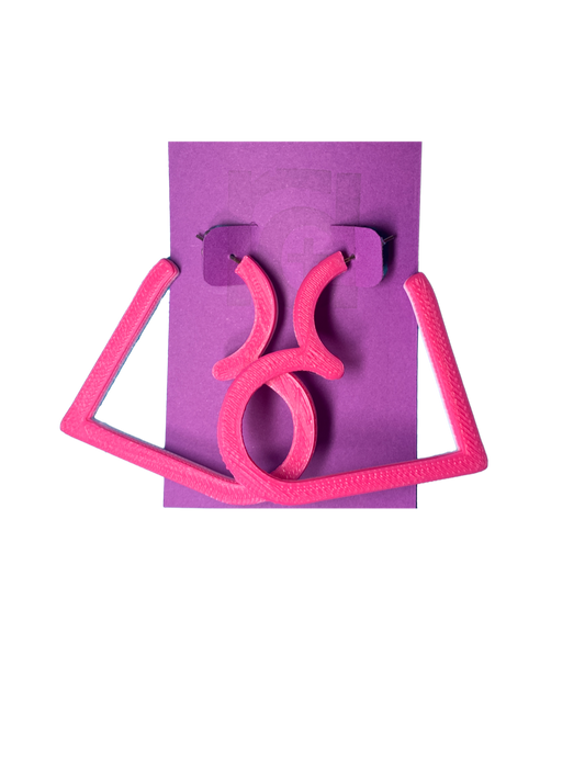 On a purple R+D card is a pair of 3D printed hoops. They are in the shape of a heart with bright hot pink visible on the top layer. Printed with a plant based filament, there are three colors layered: hot pink, light pink, and white. 