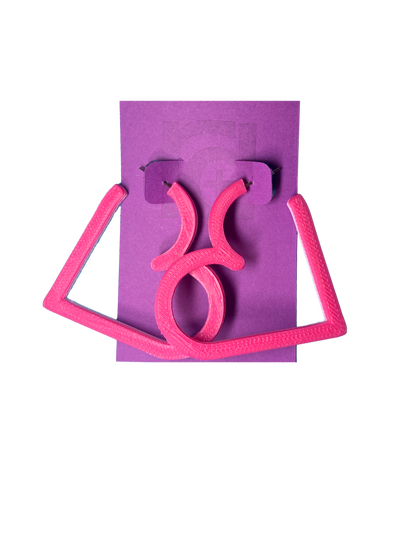 On a purple R+D card is a pair of 3D printed hoops. They are in the shape of a heart with bright hot pink visible on the top layer. Printed with a plant based filament, there are three colors layered: hot pink, light pink, and white. 