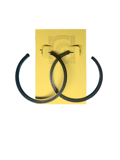Shown on a yellow R+D card are two 3D printed hoop earrings. They are large two inch hoops in a black that are lightweight and plant based.