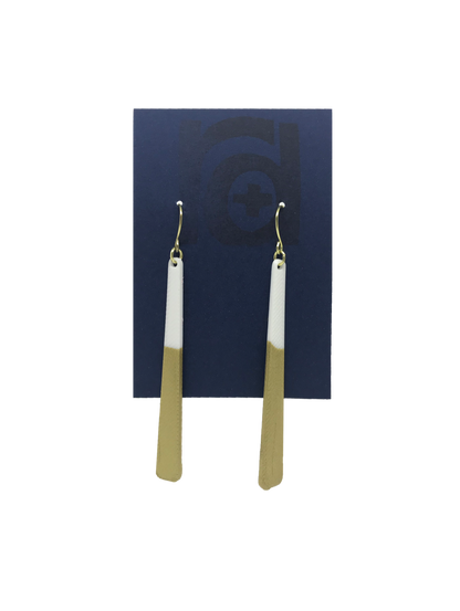 Shown on a sustainable dark blue earring card, these earrings are long dangles that flare out slightly. The white plant based earring is dipped into metallic gold paint to give a perfect shimmering accent. 