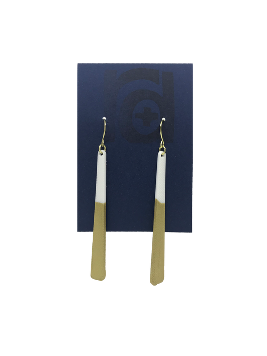 Shown on a sustainable dark blue earring card, these earrings are long dangles that flare out slightly. The white plant based earring is dipped into metallic gold paint to give a perfect shimmering accent. 