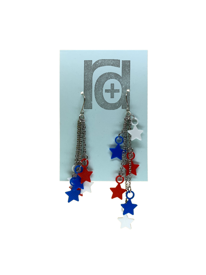 On a light blue earring card are two earrings. They have red, white, and blue stars that hang at the end of chains. The stars can be pulled to hang all at one length (shown on the left earring) or at various lengths (shown on the right earring). 