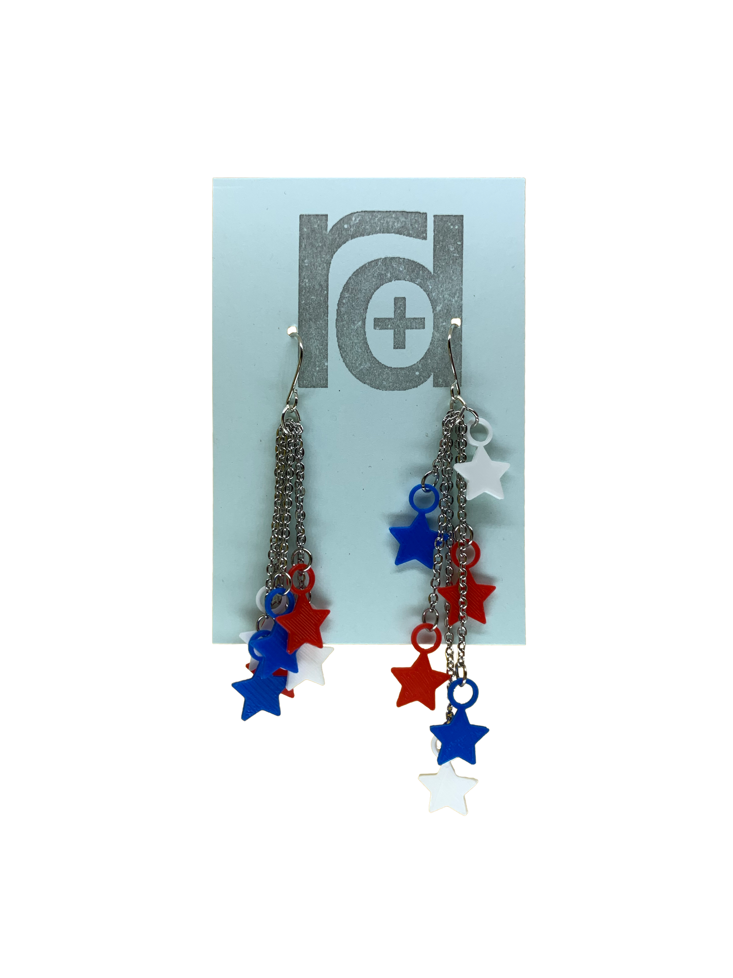 On a light blue earring card are two earrings. They have red, white, and blue stars that hang at the end of chains. The stars can be pulled to hang all at one length (shown on the left earring) or at various lengths (shown on the right earring). 