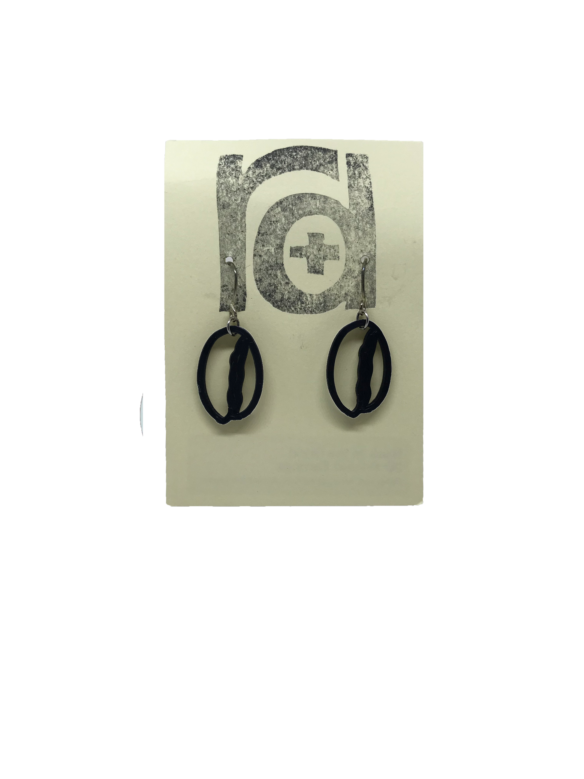 Shown on a light tan earring card are two earrings that are shaped like coffee beans. 