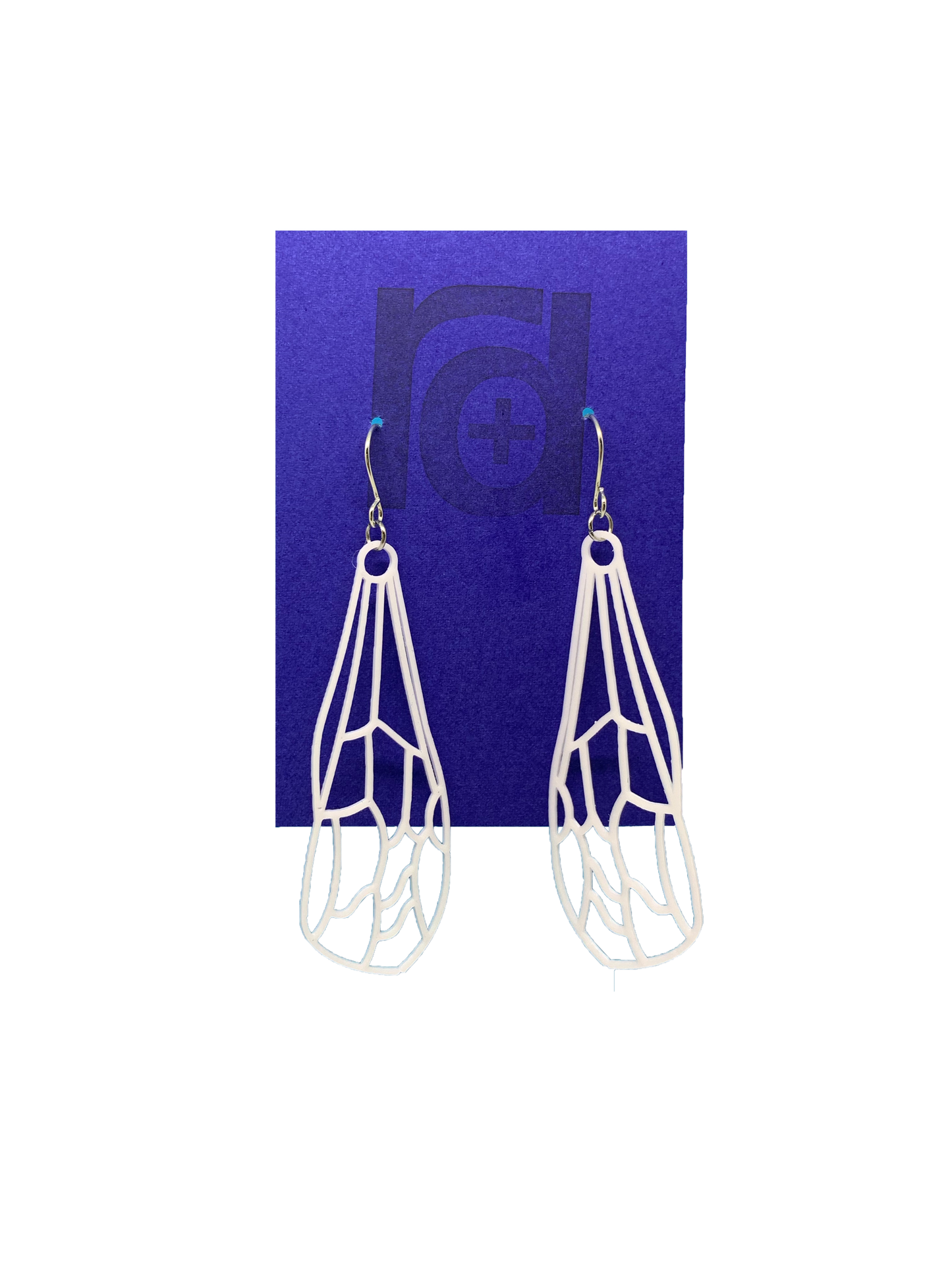 Hanging off of a bright blue earring card are two earrings. They are white and show a delicate wing of a dragonfly or insect with all the veins.