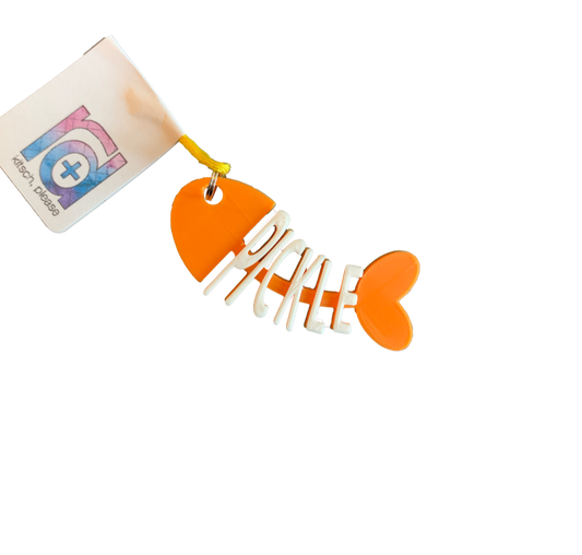 There is a cat tag that is shaped like a cartoon fish that has been eaten. The head, tail, and backbone is bright orange.  Where the bones would be, there are letters to  form the name Pickle in white. 