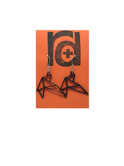 Shown on a bright orange earring card are two R+D earrings. They are geometric line shapes of birds flying. These sustainable 3D printed earrings are printed in black.