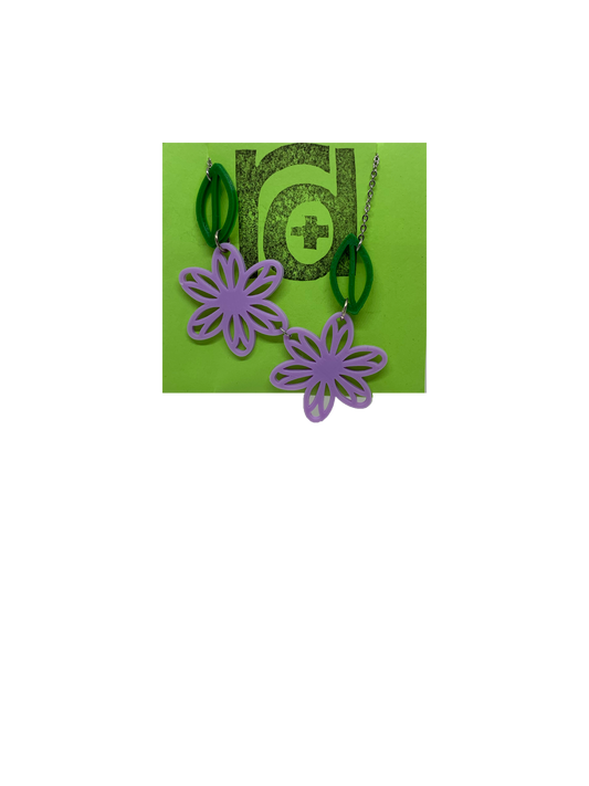 On a bright green necklace card is a asymetrical necklace with two light purple flower blossoms and two kelly green leaves. 