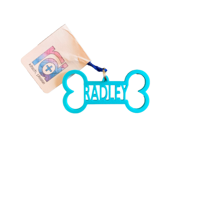 A bright teal dog bone tag is pictured. It is 3D printed and has the name Radley in the center. It can be customized to any pet name and to 15 other colors. 