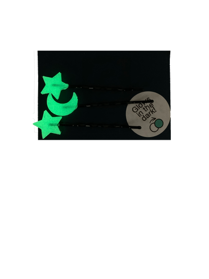 Shown on a dark navy blue paper card are three bobby pins with 3D Printed pieces attached to the ends. There are two shape like stars and one shaped like a cresent moon. They glow in the dark; here they are shown in the glowing green color they appear after being charged and brought to a dark place.