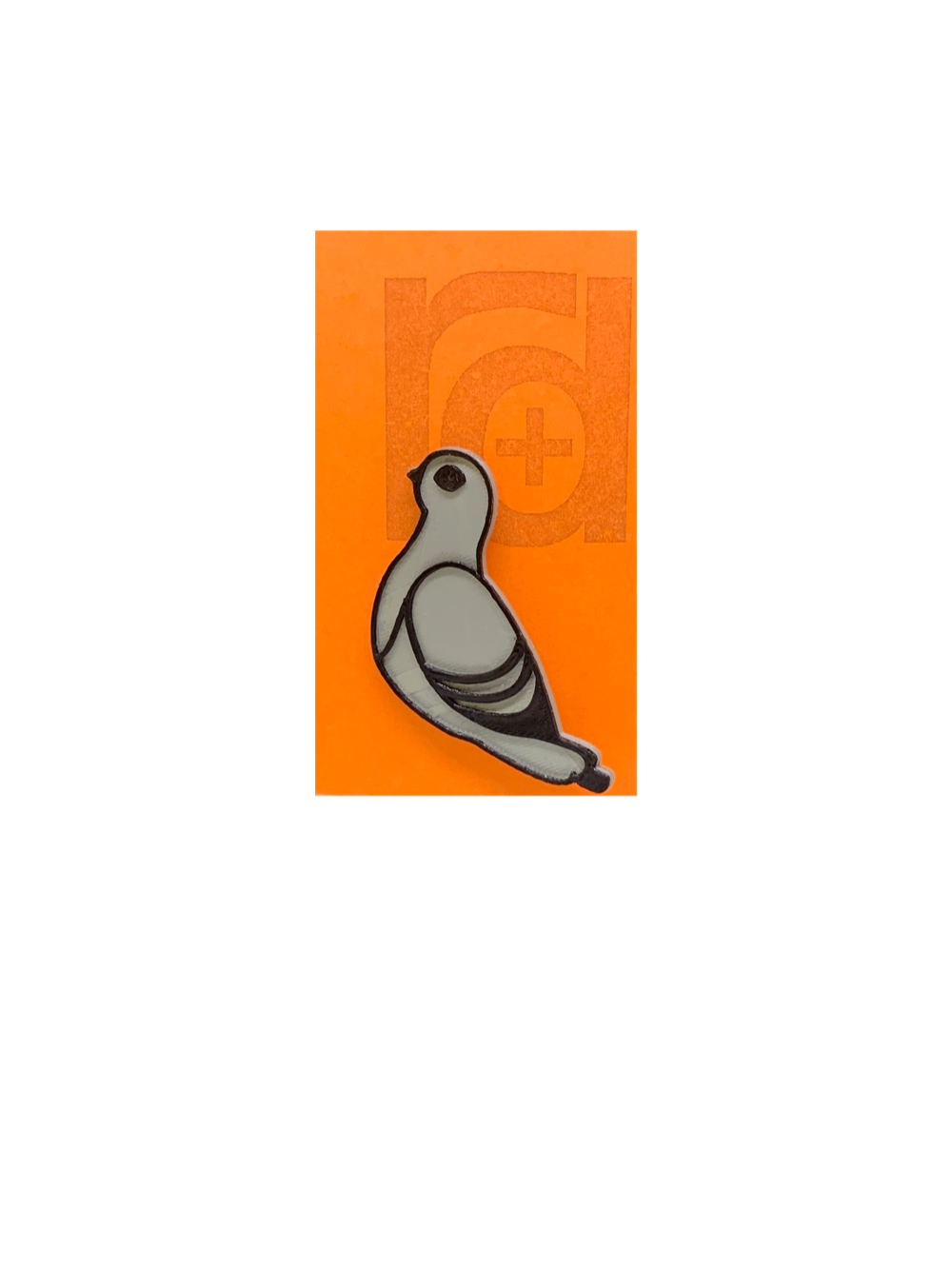 On our orange R+D pin card is a silver and grey pin shaped like a pigeon. 