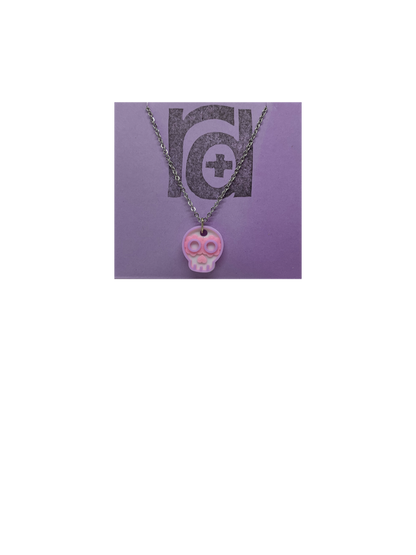 Shown on a light purple R+D earring card is a necklace with a sugar skull pendant. The small pendant is 3D printed in 3 colors: white, light pink, and light purple.