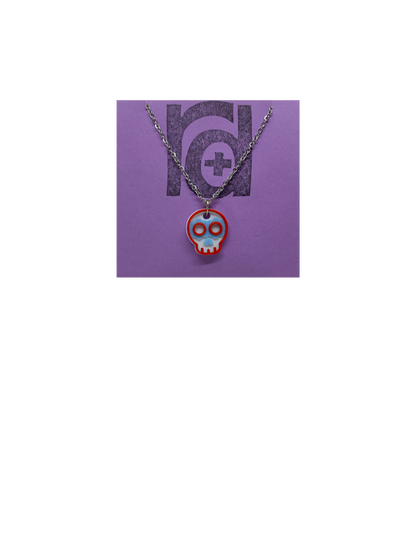 Shown on a light purple R+D earring card is a necklace with a sugar skull pendant. The small pendant is 3D printed in 3 colors: white, light blue, and red. 
