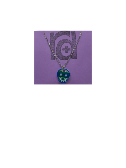Shown on a light purple R+D earring card is a necklace with a sugar skull pendant. The small pendant is 3D printed in 3 colors: white, green, and blue.