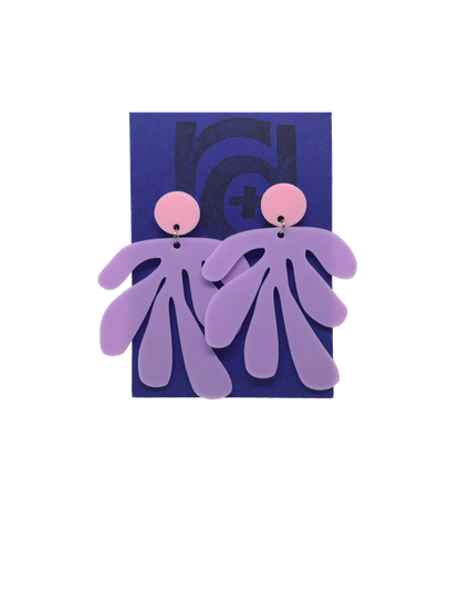Shown on a bright blue R+D earring card, these earrings have a circlar piece at the top linked to an abstract shape based on Matisse's cut out work. This set is shown in light pink and light purple plant based filament. 