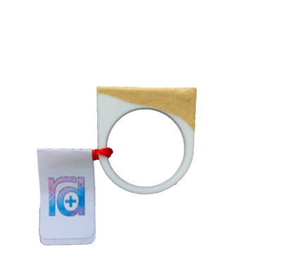 Show straight on with a R+D tag is a 3D printed ring. It is printed in a white plant based filament and dipped in a gold paint. The ring is a smooth circle around the finger, but extends into a square shape at the top.