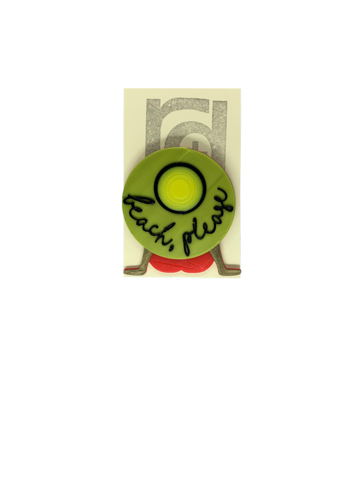 Shown on a cream colored card, this 3D printed pin shows someone sitting and relaxed back on their hands wearing  a red bathing suit and a large yellow hat that obstructs most of their body. The hat reads, beach, please in cursive.
