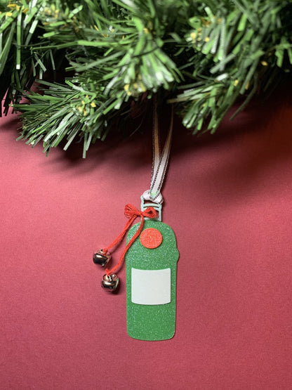Shown on a red background hanging from a wreath is a 3D printed R+D ornament. It is in the shape of a gin bottle: green with a white label and a red emblem. Tied around the neck is a red bow that has two jingle bells attached. The entire ornament is covered in glitter to give it a shimmer and shine.