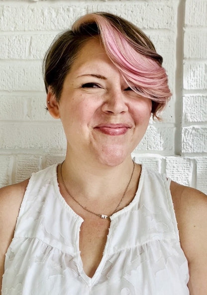 Smiling at the camera is Rebekah Thornhill. She is wearing a necklace with RT 3D printed around a metal bar in white. 