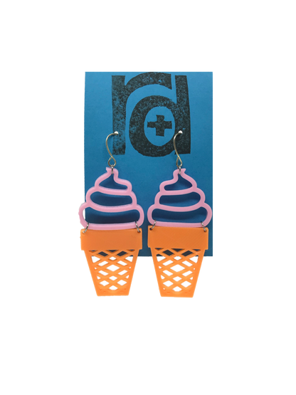 Two earrings shaped as ice cream cones; the top is a pink swirled shape like soft serve and the bottom is orange like a sugar cone. 