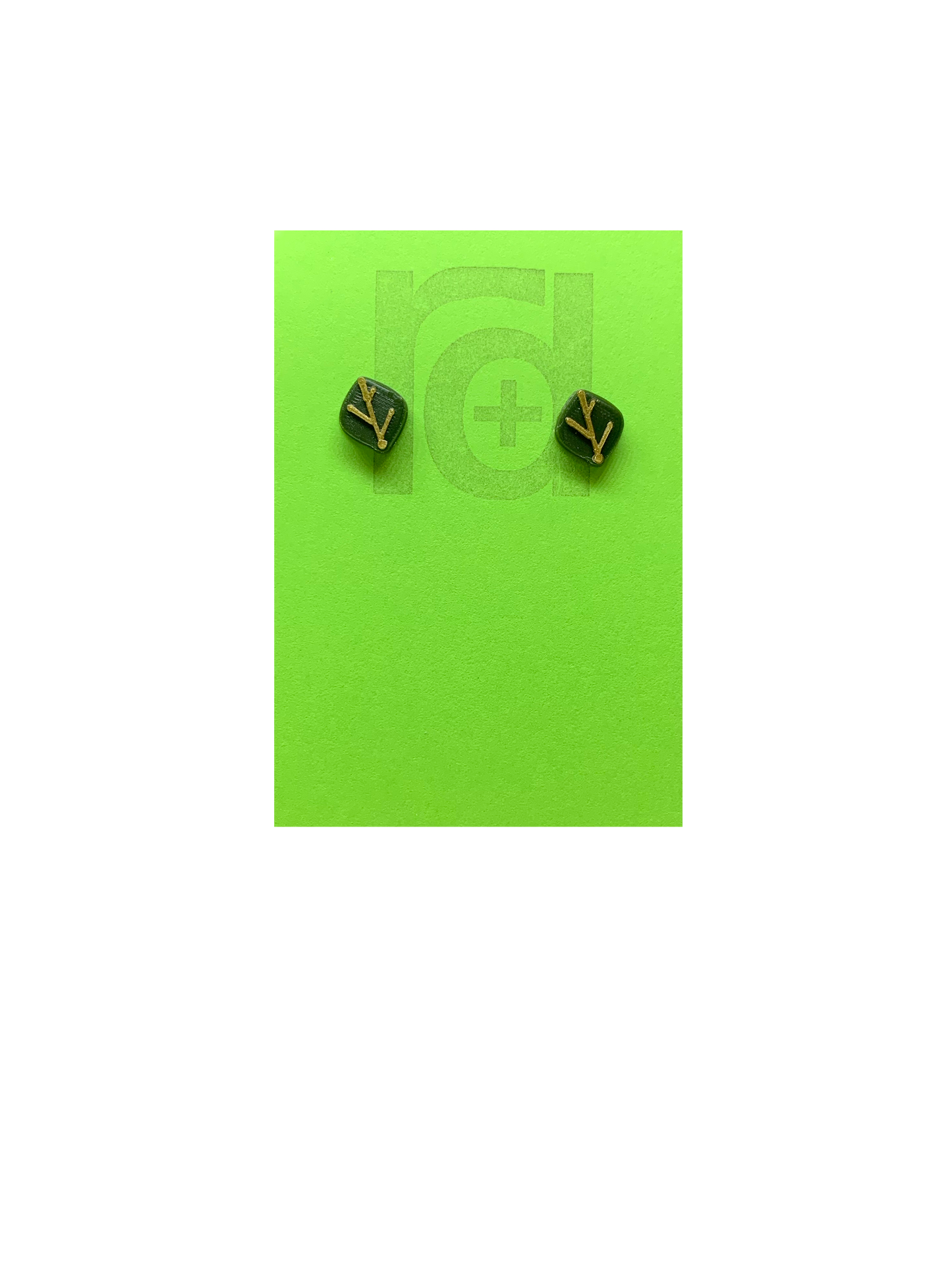 On a bright green earring card are 2 studs shaped as leaves. Each leaf is a olive green color and has veins that are gold. Not only do theres 3D printed earrings look like plants, they're made from them!