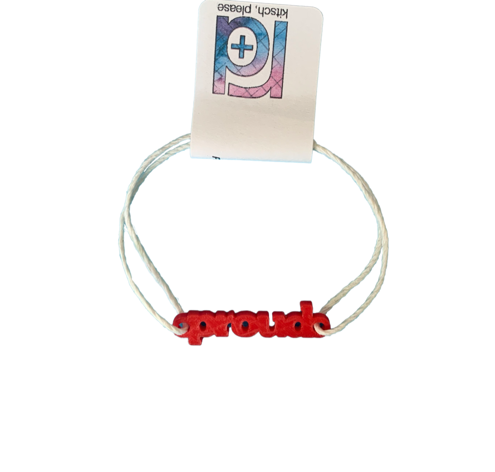 With an R+D tag, there is bracelet with a 3D printed charm. The adjustable cord on the bracelet is a white organic cotton. The charm is bright red and says proud in block letters. 