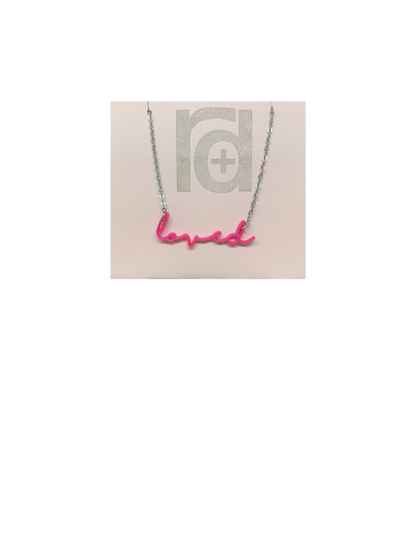 On a necklace card is a 3D printed necklace in hot pink. It is a modern cursive that says loved and can be customized to other names or words.