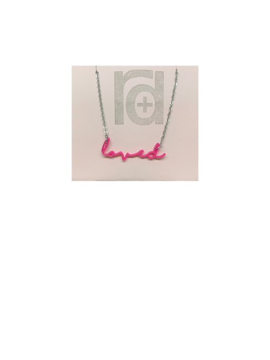 On a necklace card is a 3D printed necklace in hot pink. It is a modern cursive that says loved and can be customized to other names or words.