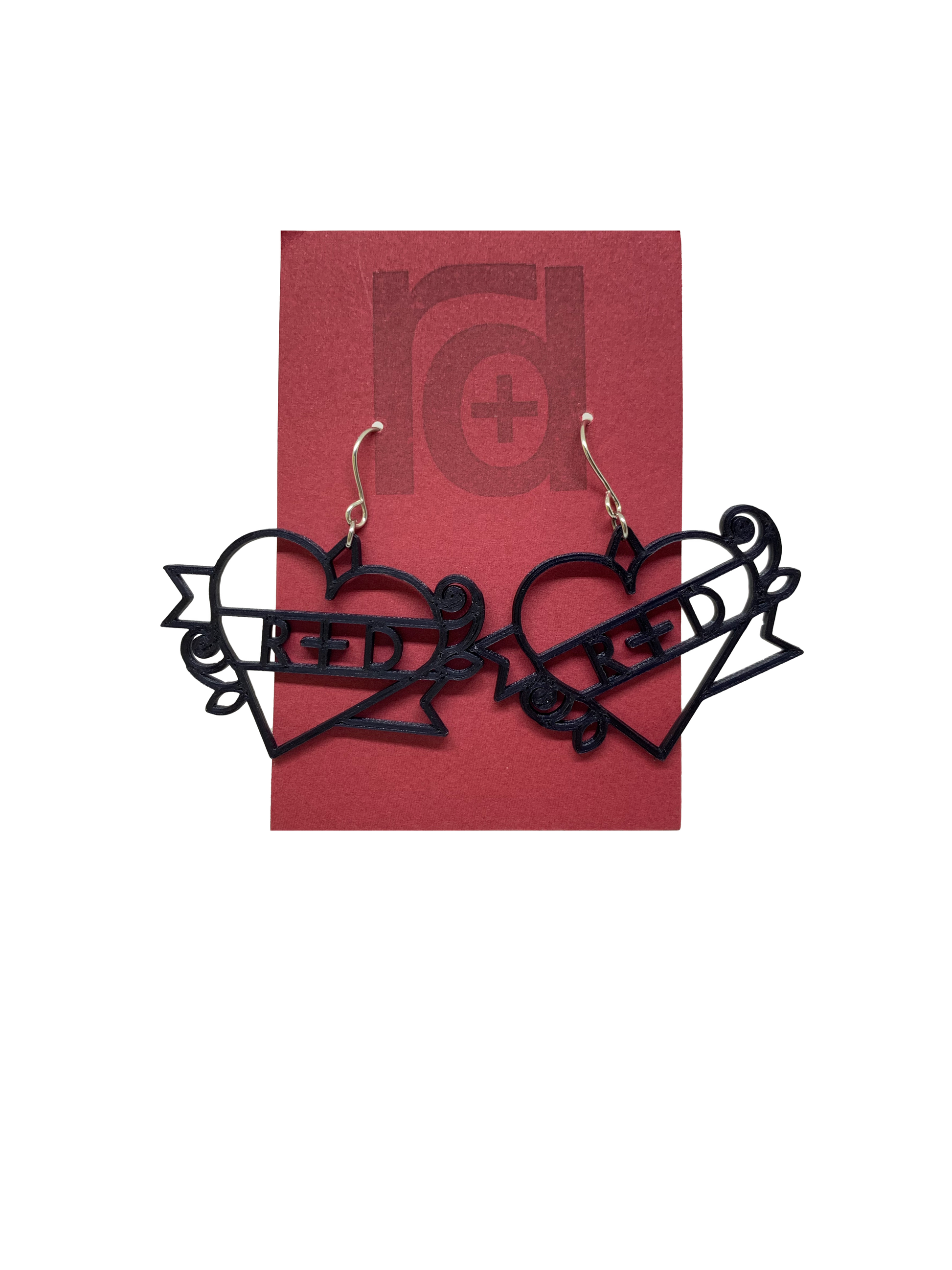 On a dark red earring card are two black R+D earrings. The earrings are shaped as hearts with a banner twisted around it and two small roses. On the banner is reads R+D, which can be personalized to say anything.